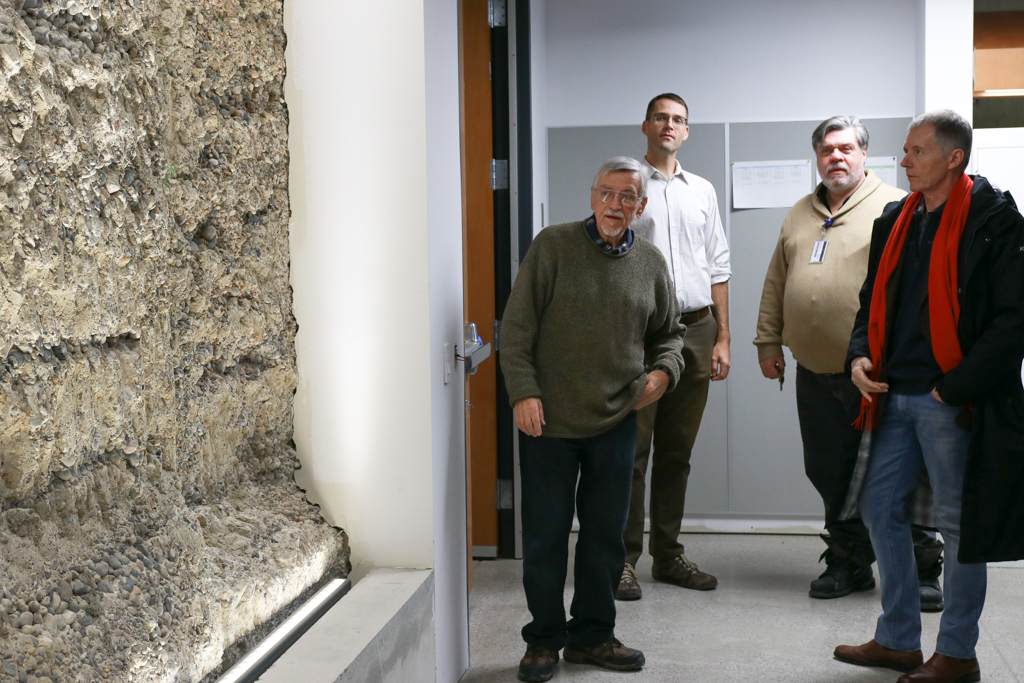 Richard Householder, Trevor Pittman, Bruce Kotowich and Alan Wildeman examine the Armouries original foundation which remains on display in the new building.
