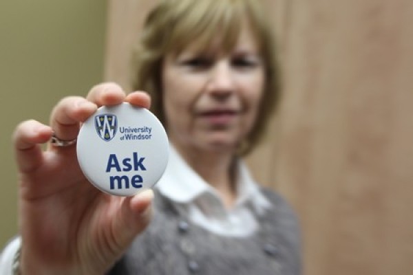 woman holding Ask Me button 
