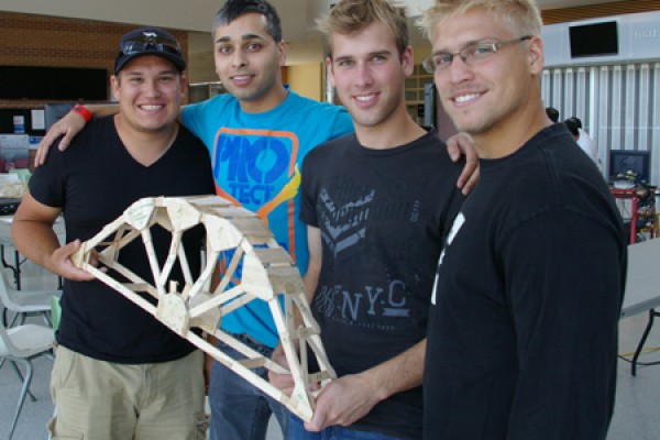 Students pose with their popsicle stick bridge