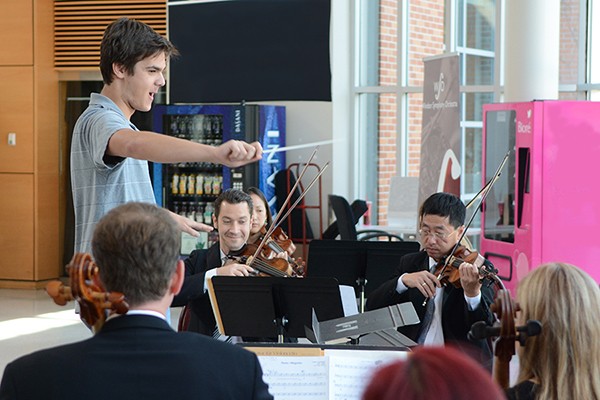 A student conducts musicians of the Windsor Symphony Orchestra.