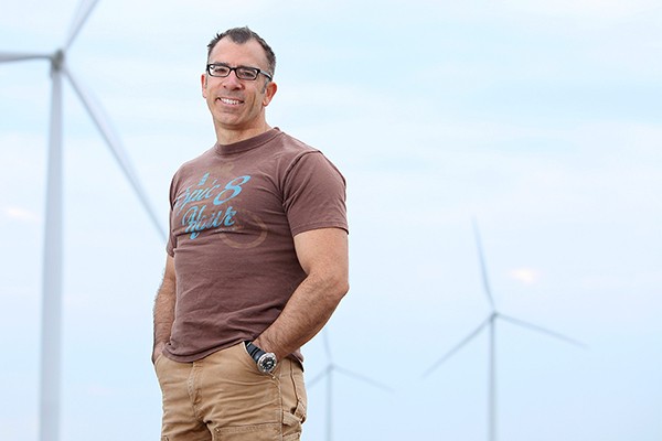 Engineering professor Rupp Carriveau stands before a Kruger Energy wind farm in Chatham-Kent.