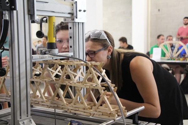 During the fourth annual popsicle stick bridge building contest, third year Civil engineering student Laura Daniel made sure her team’s structure is placed correctly in a specially-built machine that measures the force applied as the structures are crushe