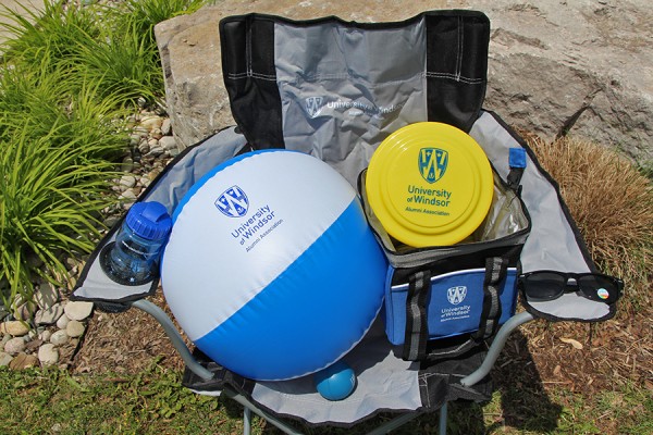 folding lawn chair, insulated cooler bag, polarized sunglasses, water bottle, inflatable beach ball, flying disk, and rubber stress ball: all bearing the alumni association logo