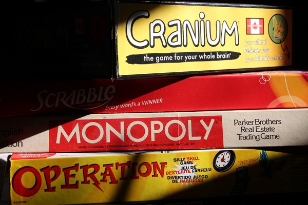 stacked game boxes: Cranium, Scrabble, Monopoly, Operation