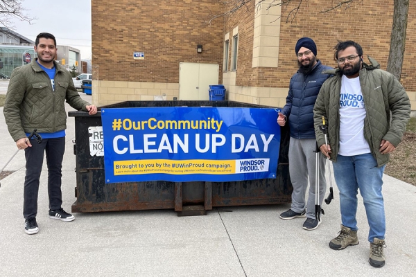 students standing in front of clean-up day banner