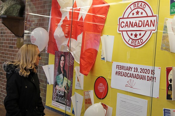 Danielle Duplessis takes in a display of “I Read Canadian Day” materials in the Leddy Library.