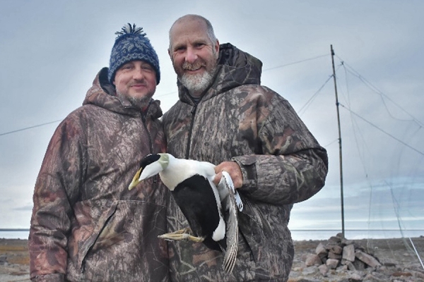 Oliver Love, Grant Gilchrist holding a seabird