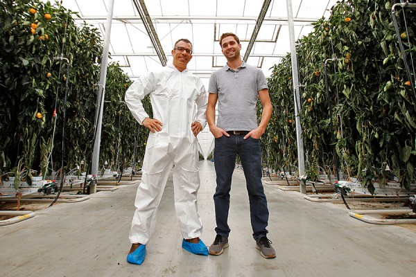 Rupp Carriveau and Lucas Semple pose inside greenhouse