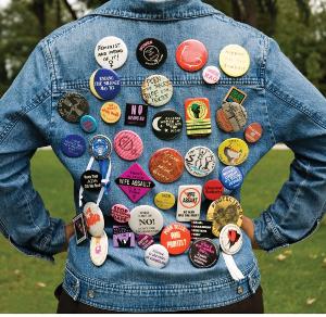 denim jacket covered in feminist slogan buttons
