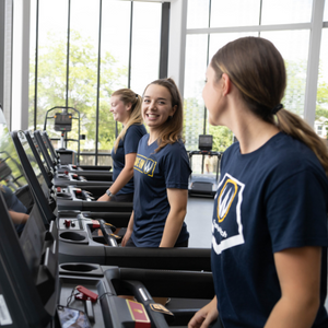 Three students on treadmills in fitness centre.